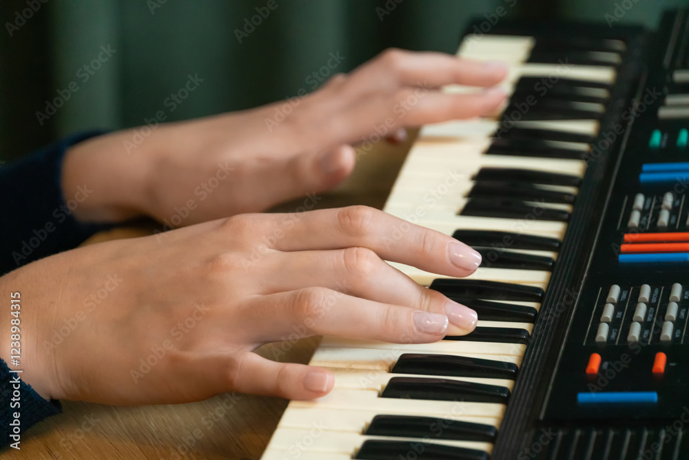 Obraz premium Fingers dancing effortlessly over the keys of an electronic keyboard, creating a captivating melody filled with skill and passion, embodying the essence of musical artistry