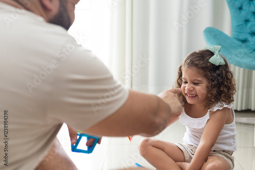 menina brincando com o pai na sala photo