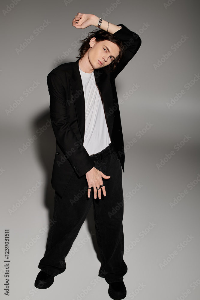 A handsome young man showcases his stylish outfit with an expressive pose in a chic indoor setting. A handsome young man showcases his stylish outfit with an expressive pose in a chic indoor setting.