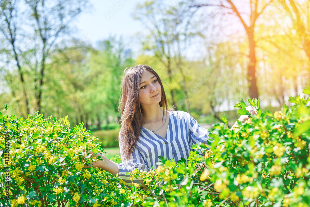 A beautiful girl in a checkered shirt walks in the park on a spring morning. A beautiful girl in a checkered shirt walks in the park on a spring morning.