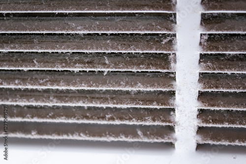 macro close-up of dusty louvered air white return air grille vent cover powder coated steel for ventilation system dirty needs cleaning abstract texture background