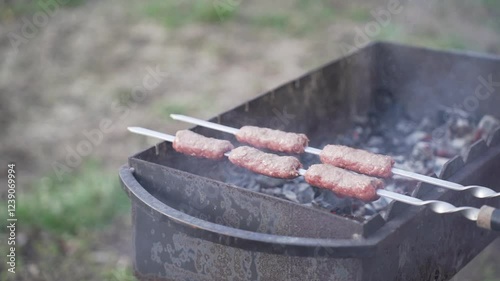 Food cooked outdoors on charcoal, hands in frame. Barbecue.