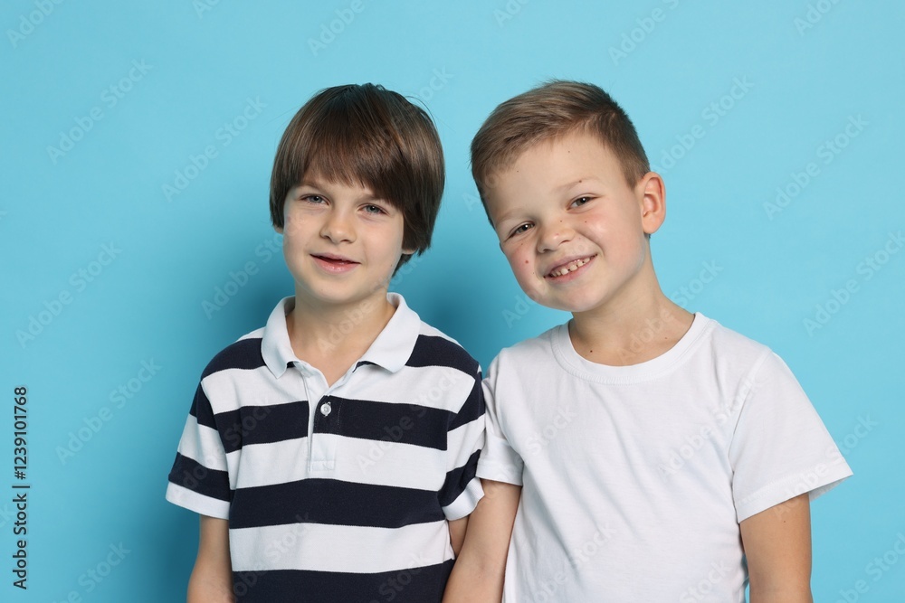 Portrait of cute brothers on light blue background Portrait of cute brothers on light blue background