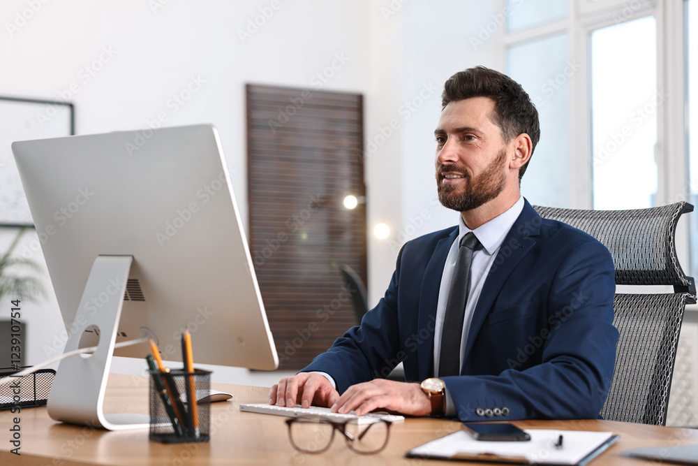 Fototapeta premium Man working on computer at table in office