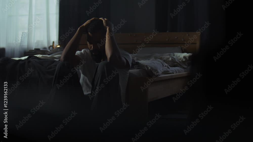 Despaired African American man cries on floor in dark bedroom Despaired African American man cries on floor in dark bedroom