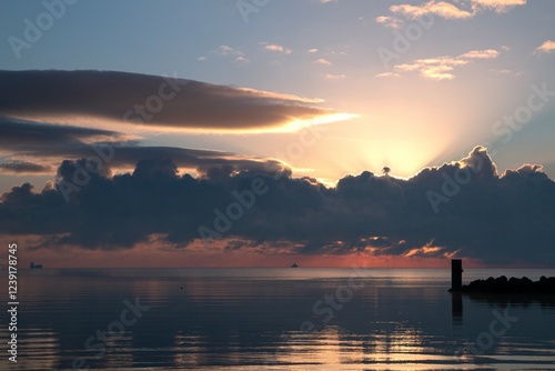 Epic skyscape with sunrays breaktung through the clouds at the Baltic Sea coast. photo