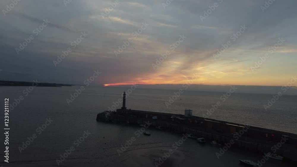 golden sunset at the pier. lighthouse and harbour in the distance. golden sunset at the pier. lighthouse and harbour in the distance.