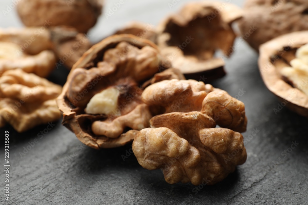 Fresh ripe walnuts and shells on black table, closeup Fresh ripe walnuts and shells on black table, closeup