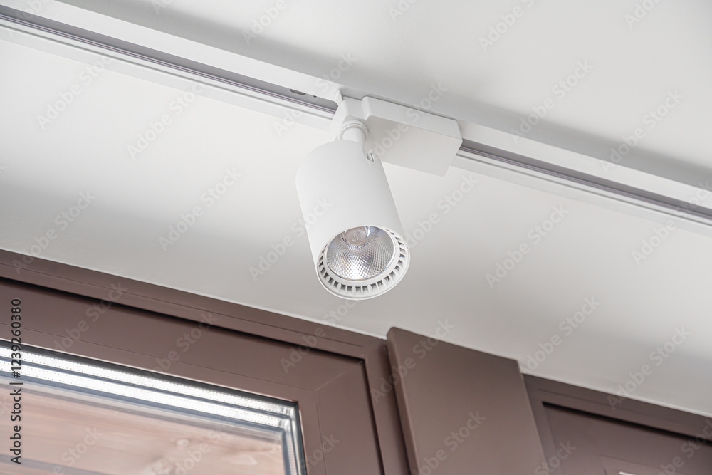 A modern track lighting system with adjustable white spotlights is elegantly mounted on the ceiling, providing focused illumination.