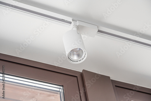 A modern track lighting system with adjustable white spotlights is elegantly mounted on the ceiling, providing focused illumination.