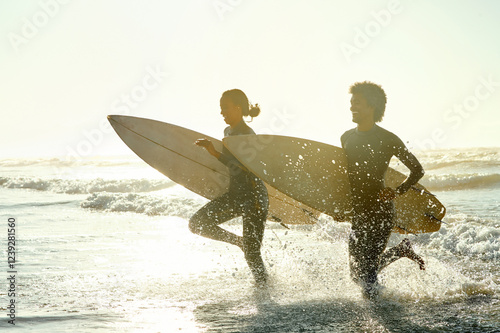 Canvas Print Sunset, running and couple in the ocean water with surfboards to practice surfing while on vacation