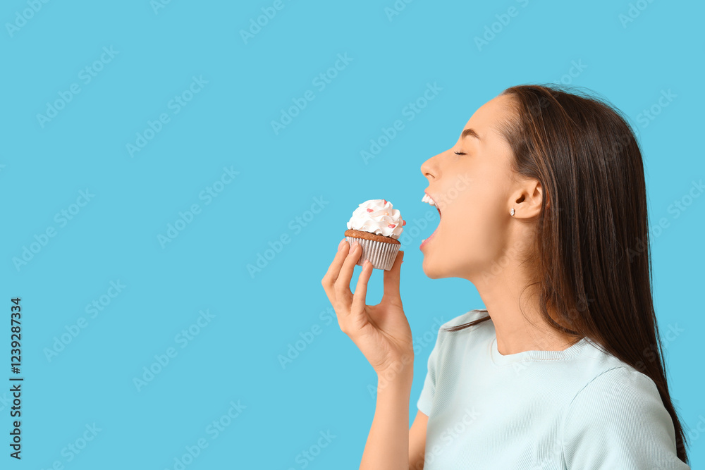 Young woman with sweet cupcake on blue background. Valentine's Day celebration Young woman with sweet cupcake on blue background. Valentine's Day celebration
