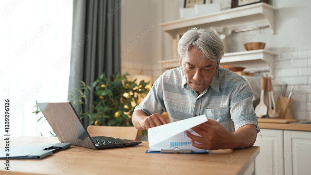Senior worker with casual cloth typing laptop while looking at financial chart and making decision. Asian elder manager looking and planning marketing strategy by using computer at home. Myrmidon. Senior worker with casual cloth typing laptop while looking at financial chart and making decision. Asian elder manager looking and planning marketing strategy by using computer at home. Myrmidon.