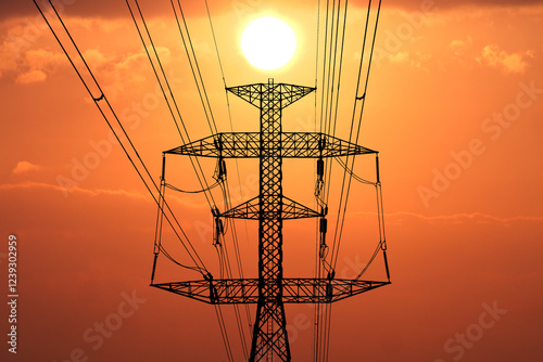 Power Lines Silhouette at Sunset: A stark silhouette of power lines against a fiery sunset sky evokes a sense of power, progress, and the intricate infrastructure that connects us. photo