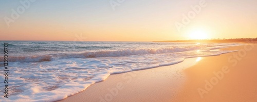 A serene beach scene at sunset, with gentle waves lapping at the sandy shore under a colorful sky.