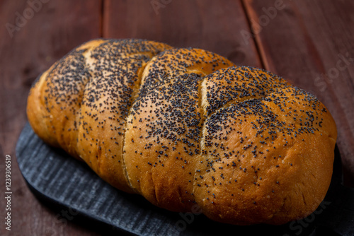 Traditional Jewish holiday challah with poppy seeds homemade on table on wooden board photo