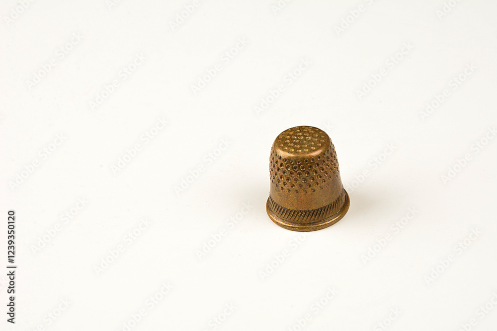 The yellow antique thimble is isolated on a white background. The yellow antique thimble is isolated on a white background.