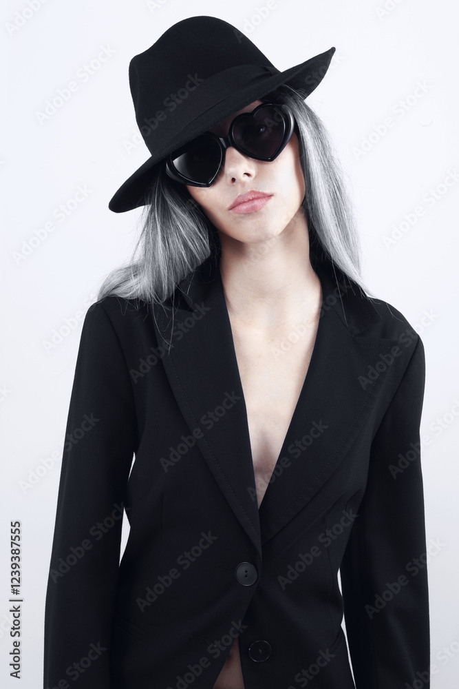 Fashion beautiful young woman with bleached long hair wearing sunglasses, black hat and black jacket, isolated on white background. For a magazine cover, advertising poster and web or shop banner Fashion beautiful young woman with bleached long hair wearing sunglasses, black hat and black jacket, isolated on white background. For a magazine cover, advertising poster and web or shop banner