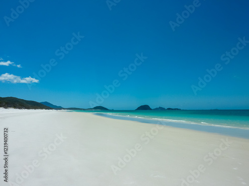 Obraz na płótnie Pristine white sandy beach stretches along turquoise waters at Whitehaven Beach, Whitsunday Islands, Queensland, Australia. Gentle waves meet powdery silica sand. Vibrant blue sky. Summer vacation w salonie