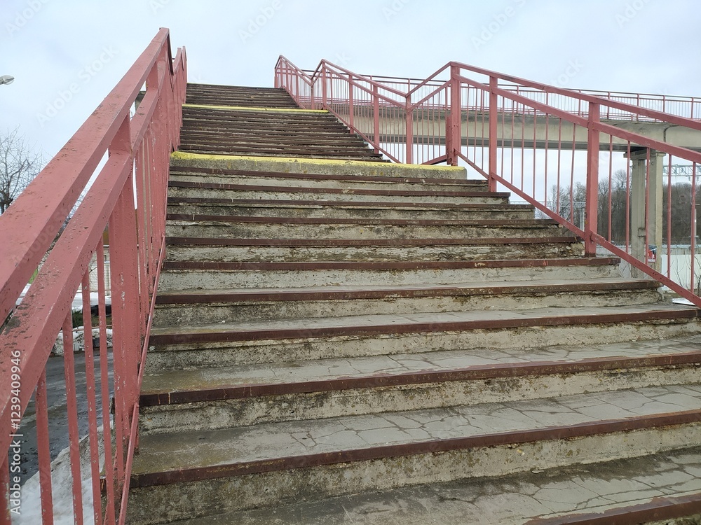Obraz premium Staircase in the city park with red railing and blue sky