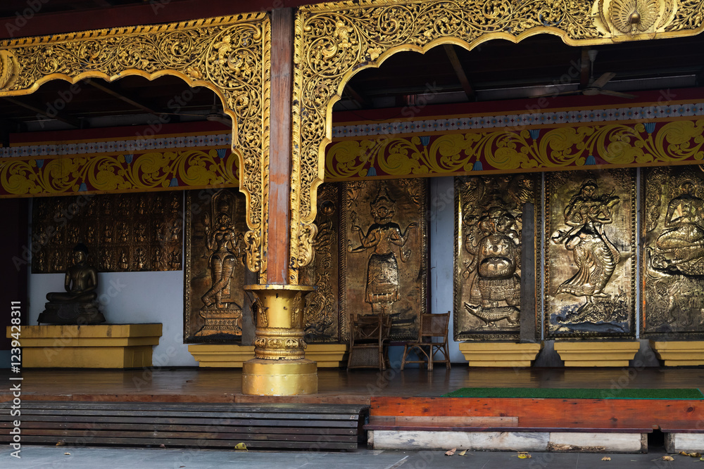 Naklejka premium Embossed images of Hindu deities placed near Buddha statue