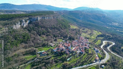 A stunning aerial drone view of Črni Kal, Slovenia, featuring the historic Castle of San Sergio atop a hill and the modern Črni Kal Viaduct, part of the A1 motorway (toll road), spanning Vipava Valley photo