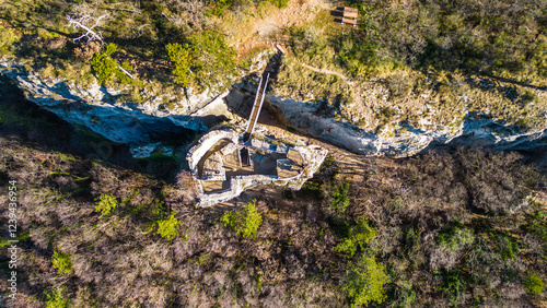 A stunning aerial drone view of Črni Kal, Slovenia, featuring the historic Castle of San Sergio atop a hill and the modern Črni Kal Viaduct, part of the A1 motorway (toll road), spanning Vipava Valley photo