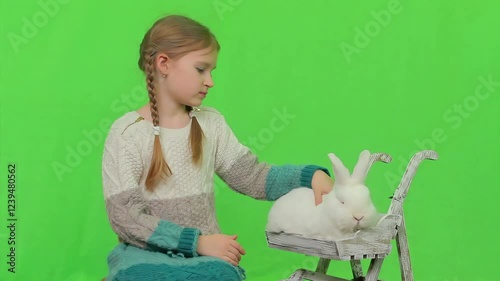 Cute girl petting a poor fluffy rabbit. High quality 4k footage