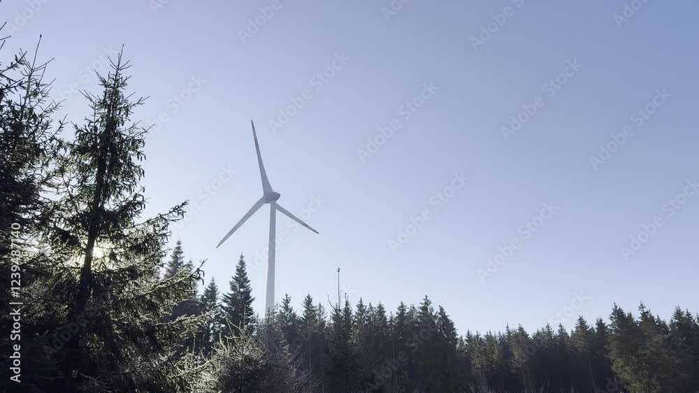 Windrad auf einem Berg vor einem blauen Himmel und der Sonne Windrad auf einem Berg vor einem blauen Himmel und der Sonne