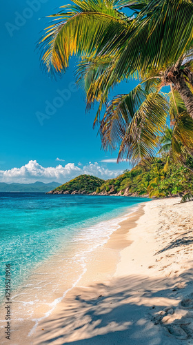 Golden sands stretch along the shore, where gentle waves kiss the beach. Lush palm trees dance in the warm breeze under a brilliant blue sky, creating a serene tropical escape photo