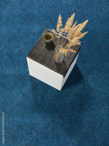 The aesthetic and minimalistic table stands on a colored carpet