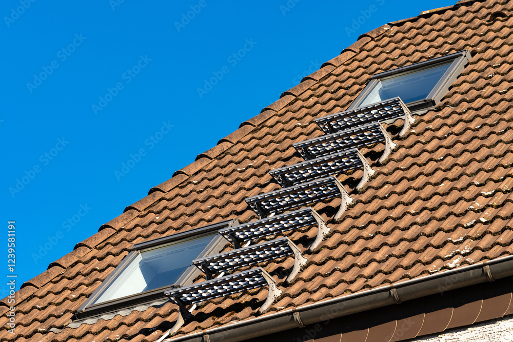 Metal stairs installed on roof with windows under clear blue sky Metal stairs installed on roof with windows under clear blue sky
