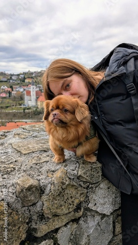 Obraz na płótnie Portrait of pretty woman and cute little brown dog with Krapina city in background, pets and animals w salonie