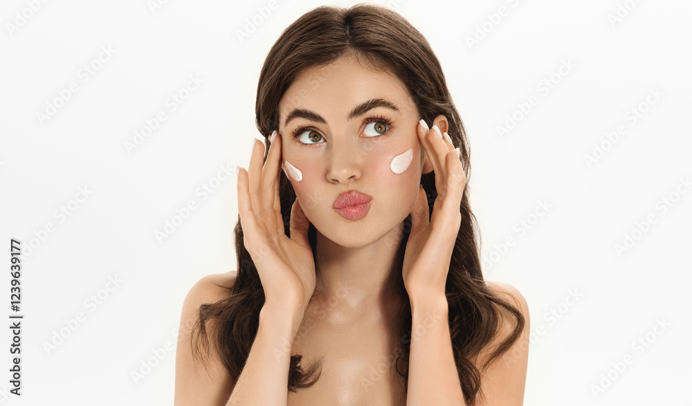 Woman gently applying moisturizing cream on cheeks as her skincare routine. Portrait of self-care, beauty and healthy skin, female model hydrates and nourishes her face with facial product Woman gently applying moisturizing cream on cheeks as her skincare routine. Portrait of self-care, beauty and healthy skin, female model hydrates and nourishes her face with facial product