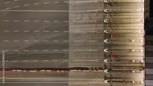 Aerial night view on the cars passing through the highway toll station
