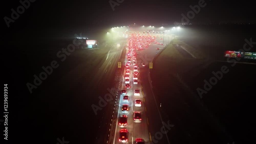 Aerial night view on the cars passing through the highway toll station