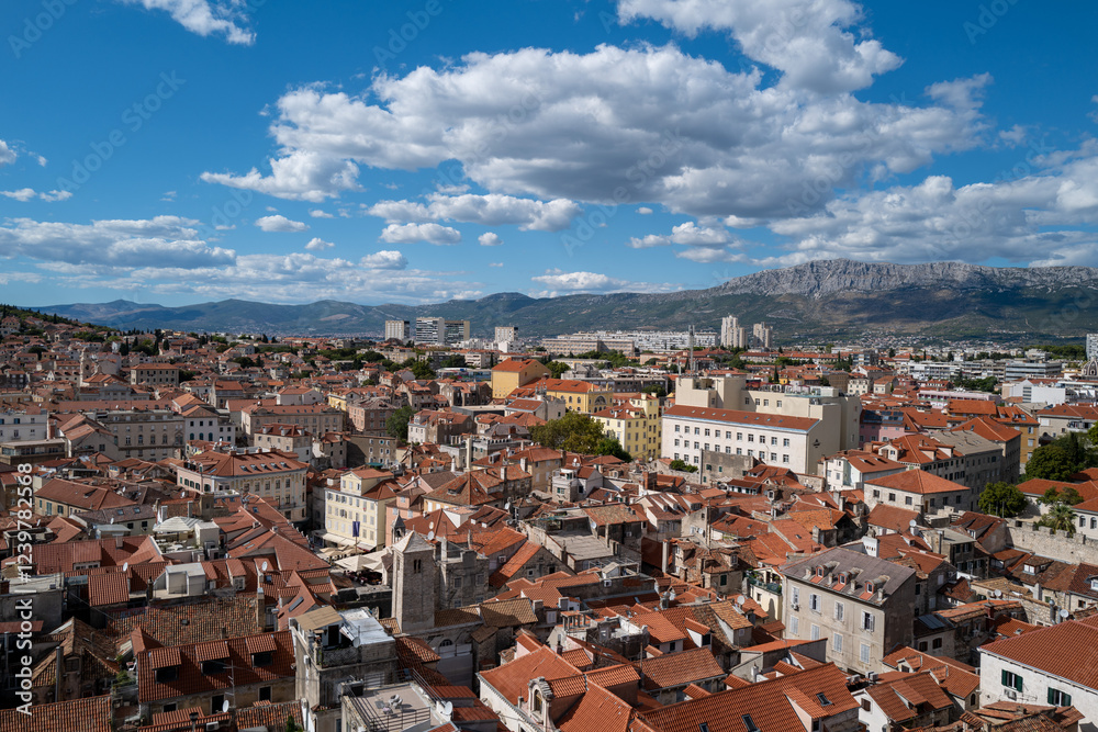 Stunning panoramic view of Split's terracotta rooftops under a vibrant blue sky, with majestic mountains in the background. Stunning panoramic view of Split's terracotta rooftops under a vibrant blue sky, with majestic mountains in the background.