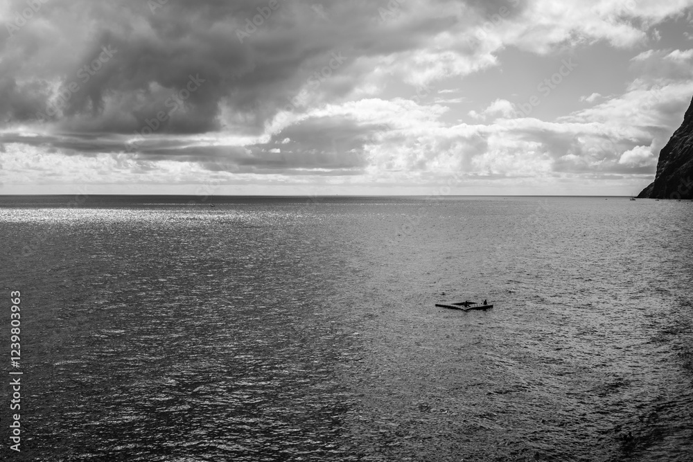 Ταπετσαρία A lone person finds serenity on a small raft adrift in a boundless ocean under a brooding sky