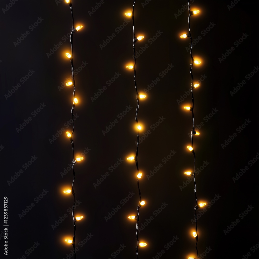 Three string lights hanging vertically in the dark. A warm and cozy Christmas festive background with small bulbs glowing yellow. Three string lights hanging vertically in the dark. A warm and cozy Christmas festive background with small bulbs glowing yellow.