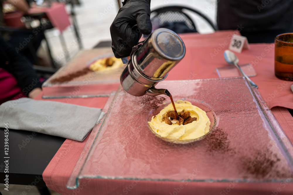 A barista expertly pours espresso over a creamy dessert, creating a delightful culinary experience.