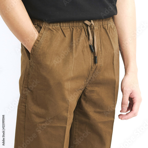 Brown drawstring pants are worn by an individual in a simple, light background, ideal for comfort during casual outings