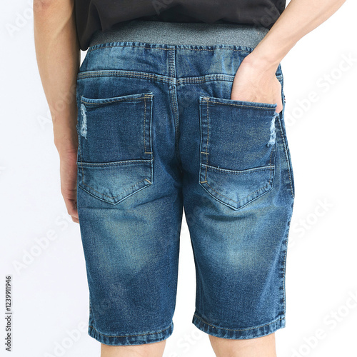 Model wears trendy blue denim shorts featuring back pockets, suitable for casual summer outings in a minimalist studio environment