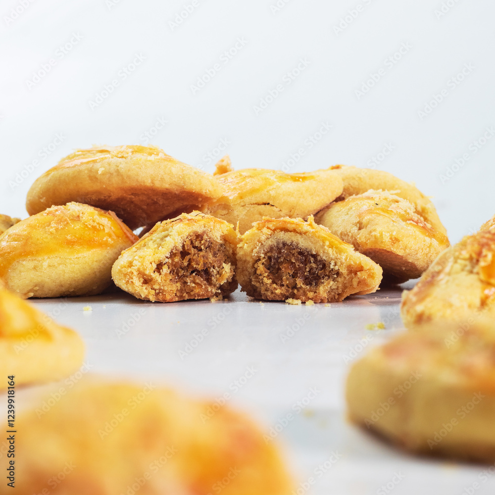 Indonesian nastar snack with pineapple jam filling. Assorted pastries with golden crusts and sweet cinnamon filling are beautifully displayed. The aroma of freshly baked goods fills the air