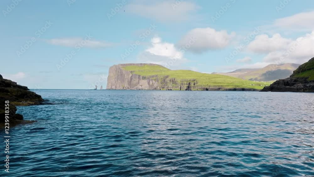 A peaceful ocean view in the Faroe Islands with lush green cliffs and clear blue skies A peaceful ocean view in the Faroe Islands with lush green cliffs and clear blue skies