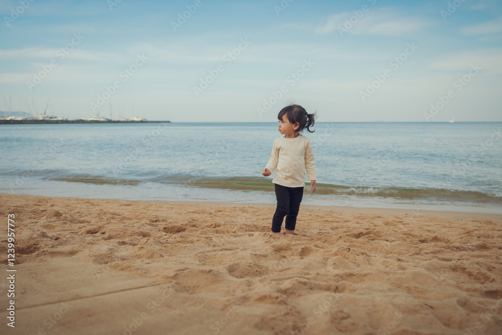 toddler baby girl standing on sea beach in Pattaya, Thailand