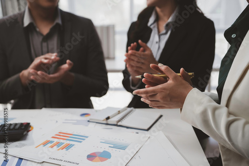 Business team clapping hands after successful presentation of financial report