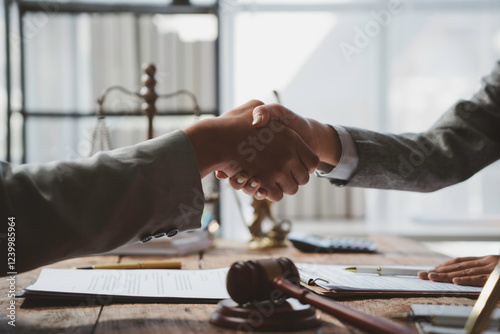 Lawyers shaking hands after signing legal contract in office