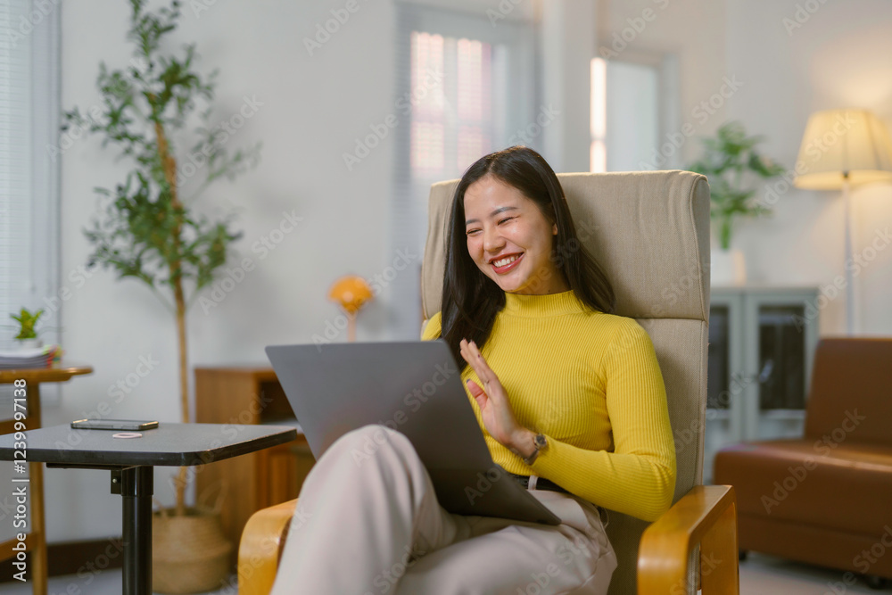 Young asian woman waving during video call on laptop at home Young asian woman waving during video call on laptop at home