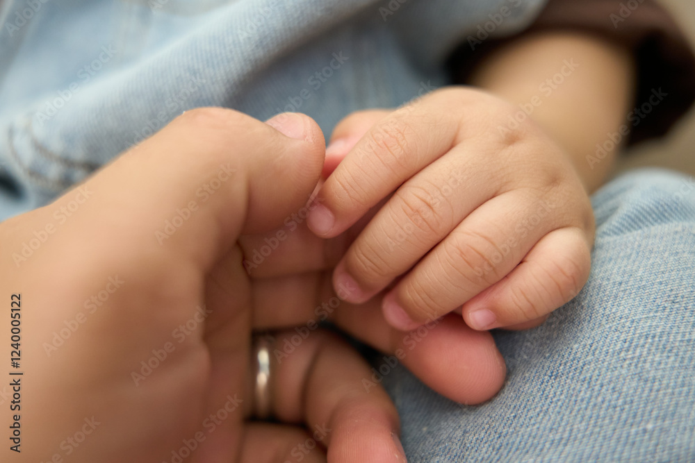 there is a baby holding the hand of a parent there is a baby holding the hand of a parent