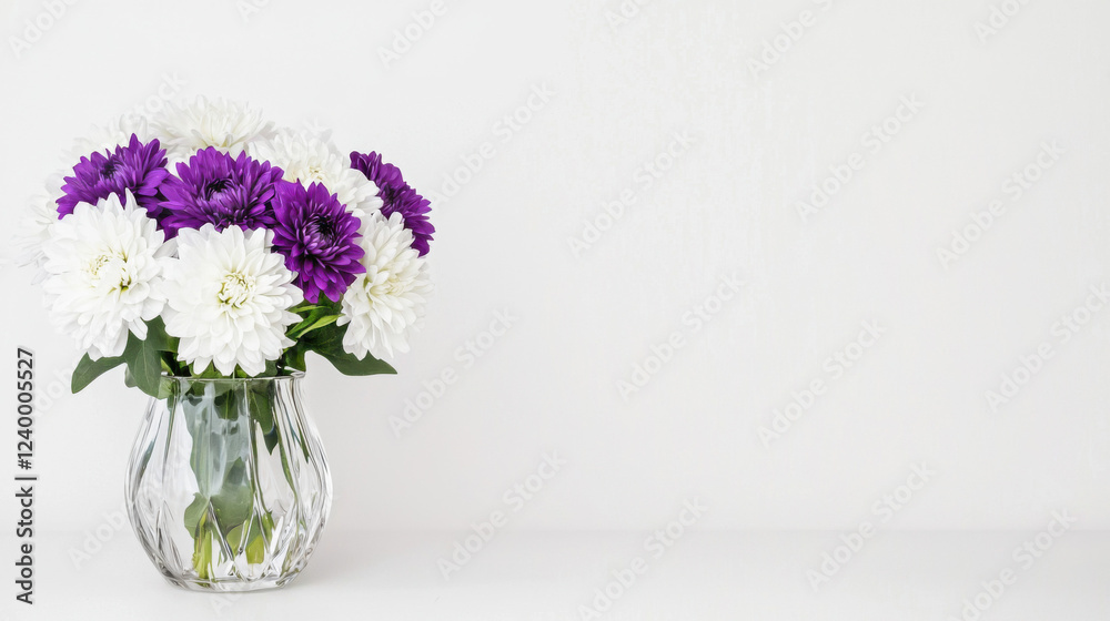 Fototapeta premium A vibrant bouquet of purple and white flowers in a clear vase, set against a minimalistic white background.